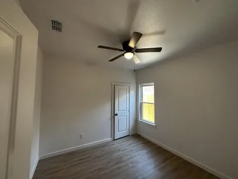 a view of backyard with wooden fence