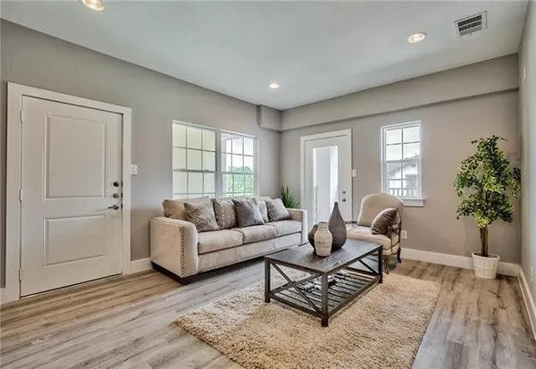 a living room with furniture and wooden floor