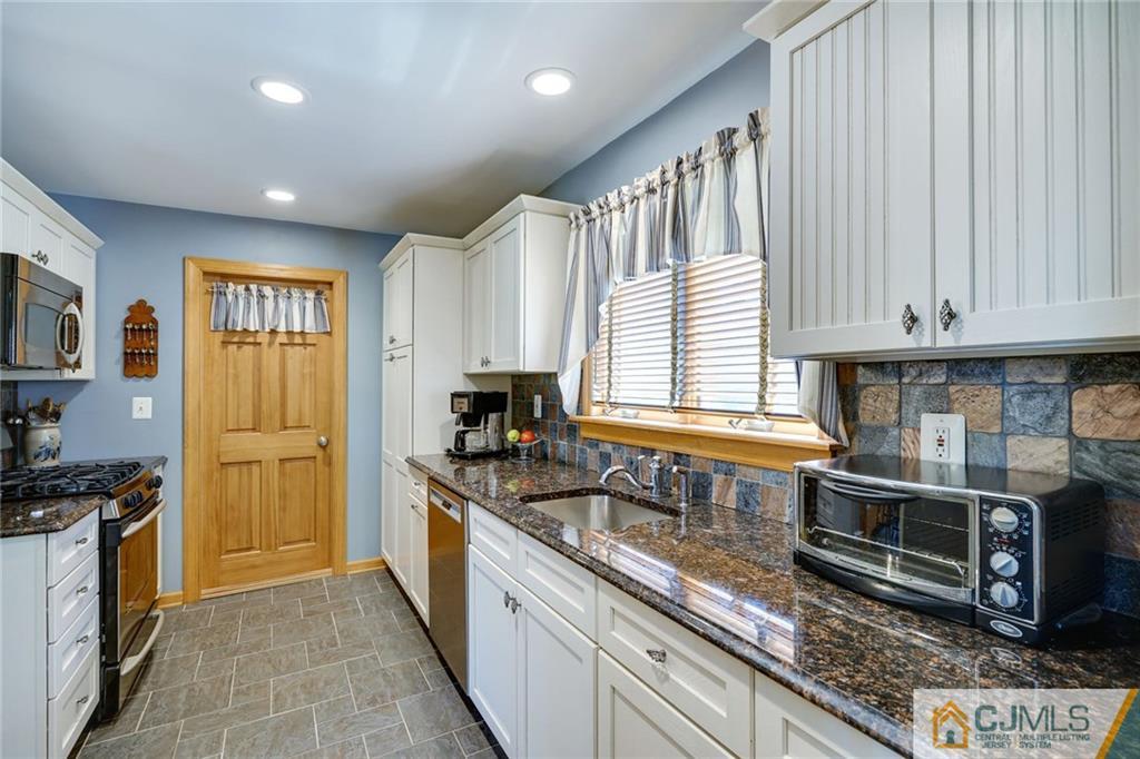 15 Carpender Road New Brunswick, NJ 08901 - Photo 10 of 25 a kitchen with granite countertop wooden cabinets stainless steel appliances and a window