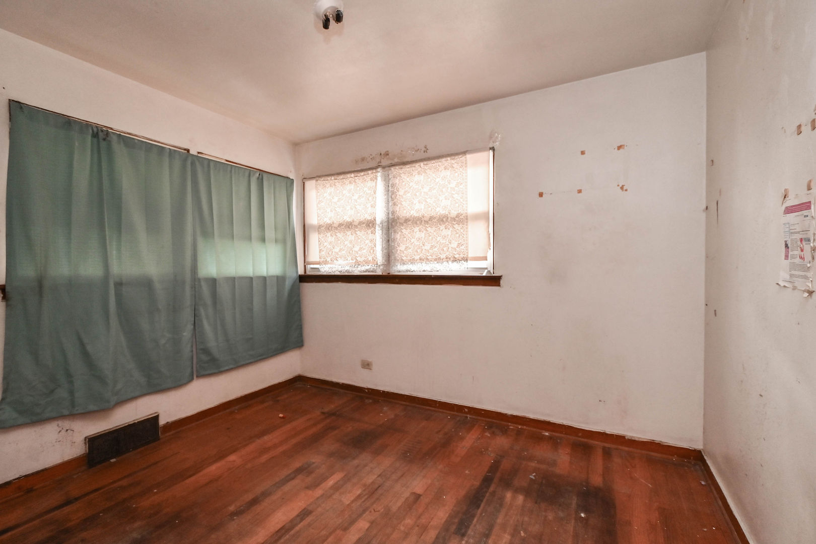629 Fulton Avenue Waukegan, IL 60085 - Photo 6 of 25 an empty room with wooden floor and windows