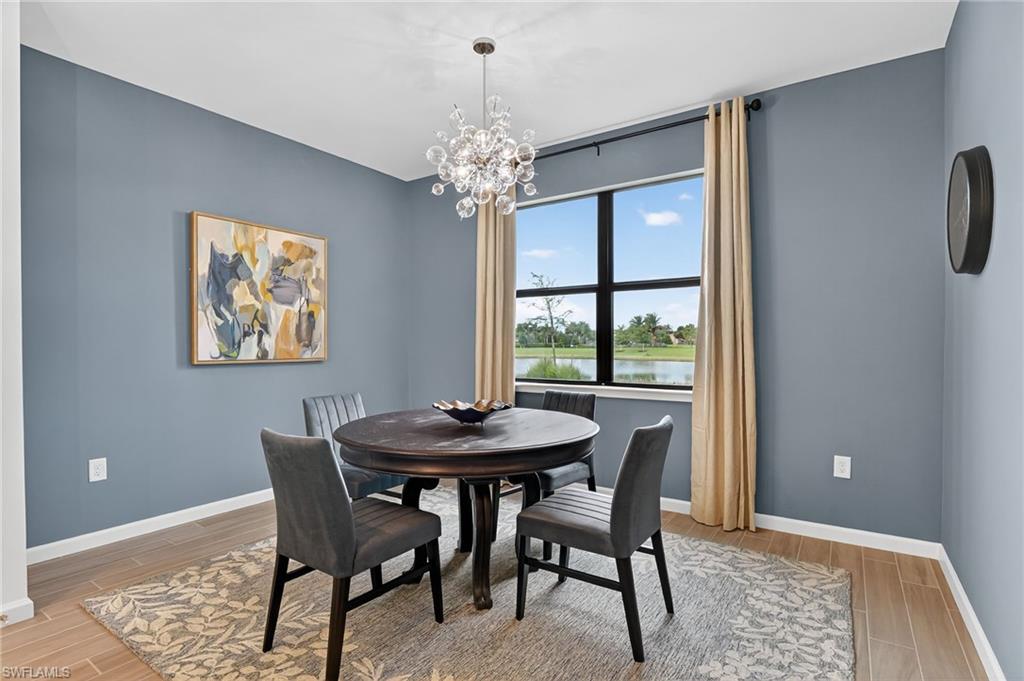 1657 Serena Avenue Naples, FL 34120 - Photo 11 of 40 a dining room with furniture a rug and a chandelier