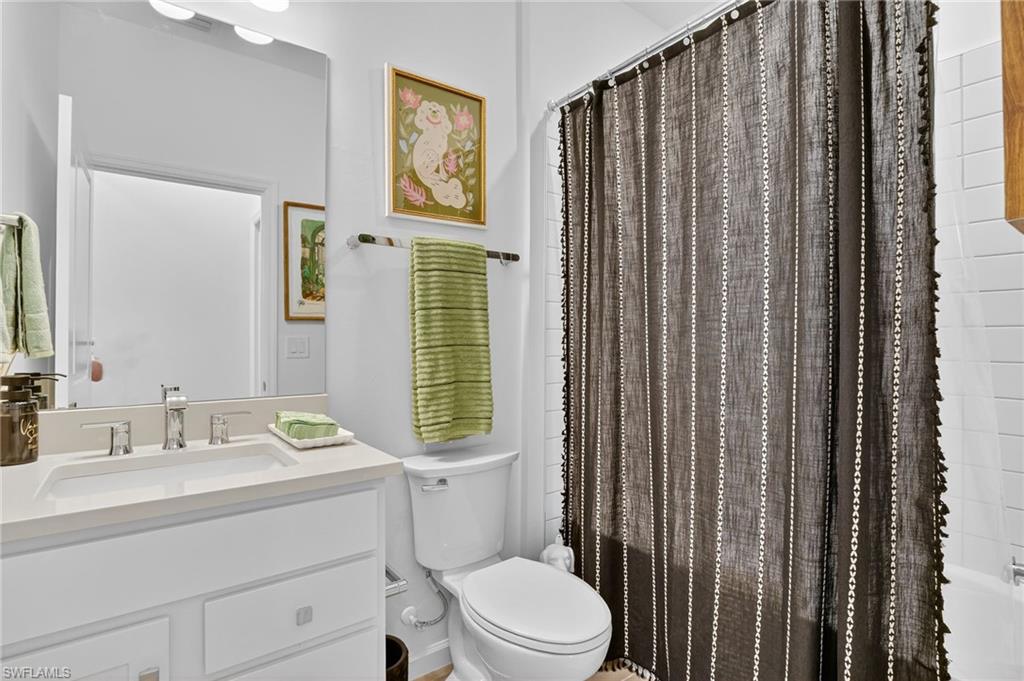 1657 Serena Avenue Naples, FL 34120 - Photo 14 of 40 a bathroom with a sink a toilet and shower curtain