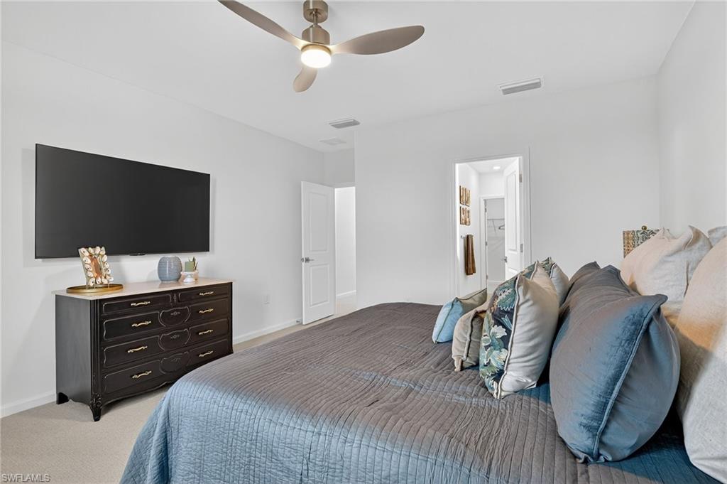1657 Serena Avenue Naples, FL 34120 - Photo 19 of 40 a bedroom with a bed and a flat screen tv