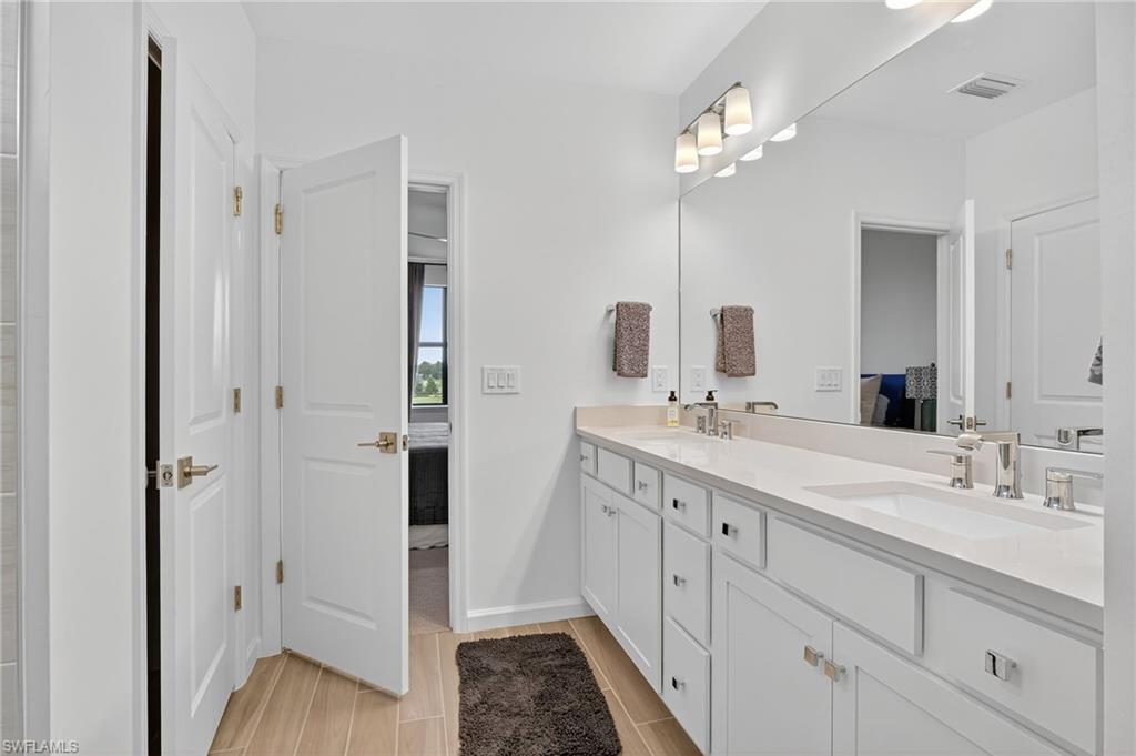 1657 Serena Avenue Naples, FL 34120 - Photo 21 of 40 a spacious bathroom with a double vanity sink a large mirror and shower