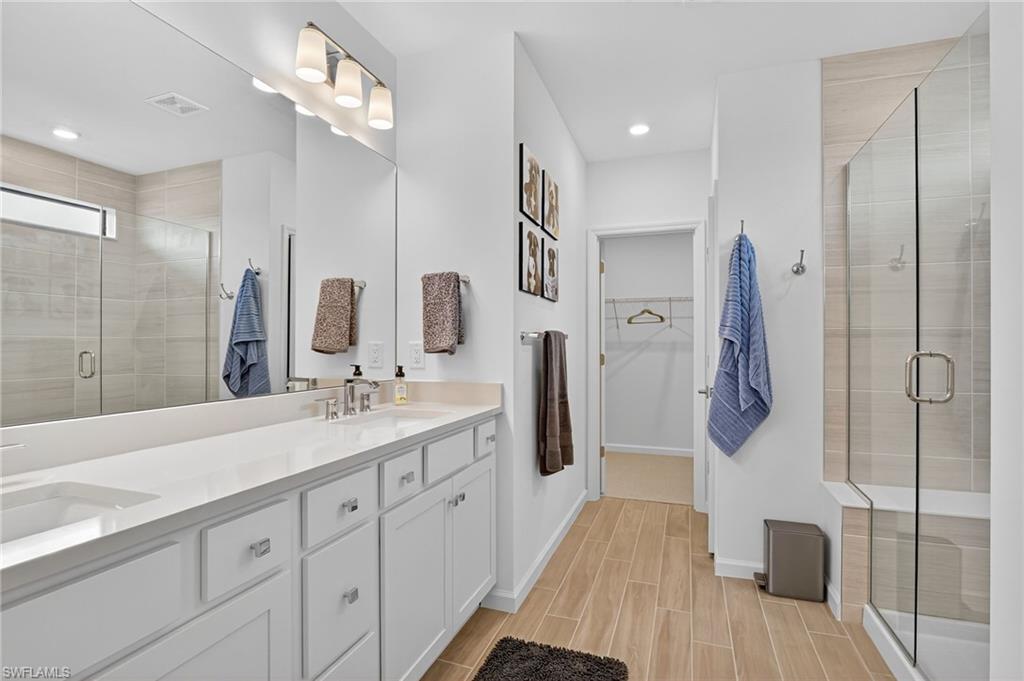 1657 Serena Avenue Naples, FL 34120 - Photo 22 of 40 a spacious bathroom with a double vanity sink shower and mirror
