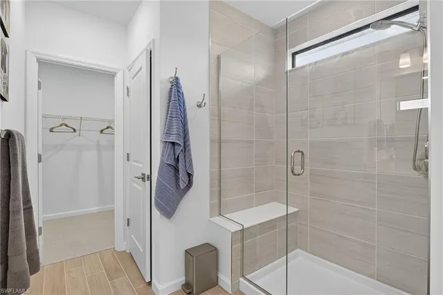 a spacious bathroom with a double vanity sink a large mirror and shower