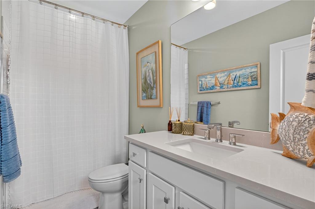 1657 Serena Avenue Naples, FL 34120 - Photo 25 of 40 a bathroom with a sink toilet and mirror