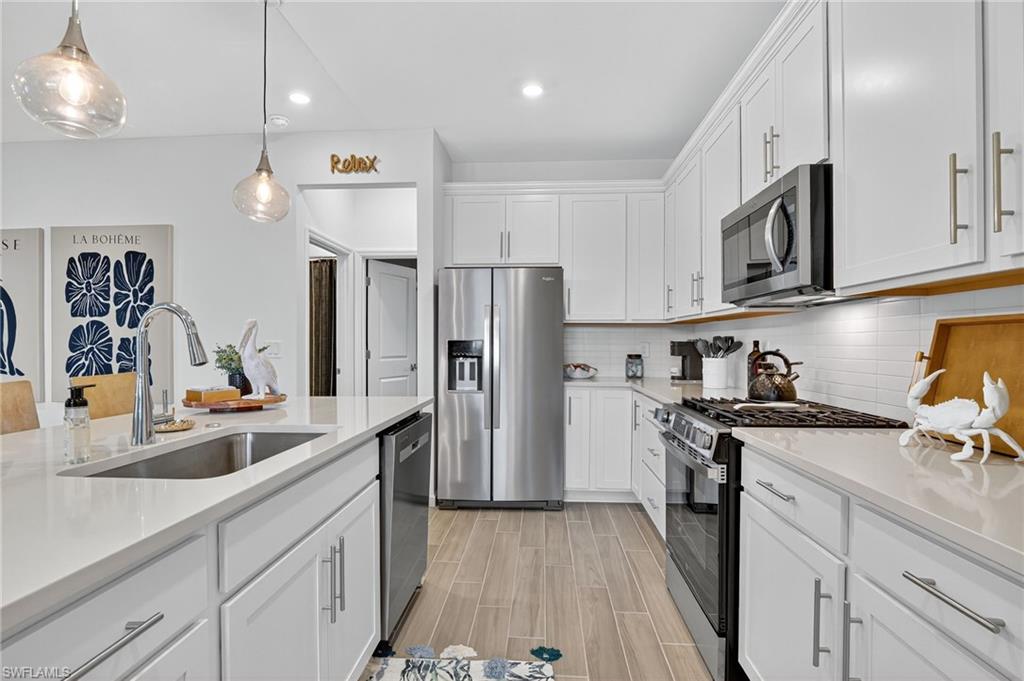 1657 Serena Avenue Naples, FL 34120 - Photo 7 of 40 a kitchen with a sink stainless steel appliances and cabinets