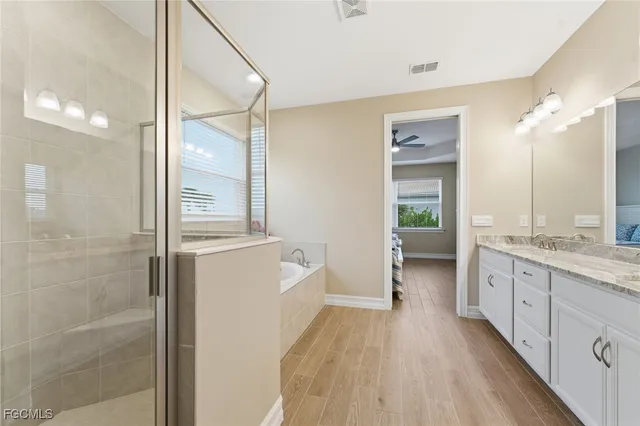 a bathroom with a granite countertop sink a mirror and a shower