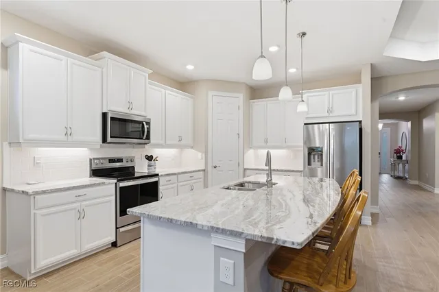 a kitchen with stainless steel appliances granite countertop a kitchen island hardwood floor sink stove and microwave