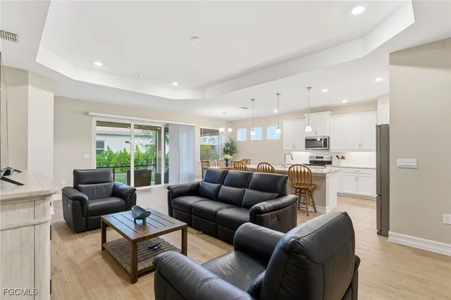 a living room with furniture kitchen view and a large window