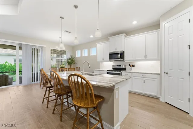 a kitchen with a table chairs refrigerator and microwave