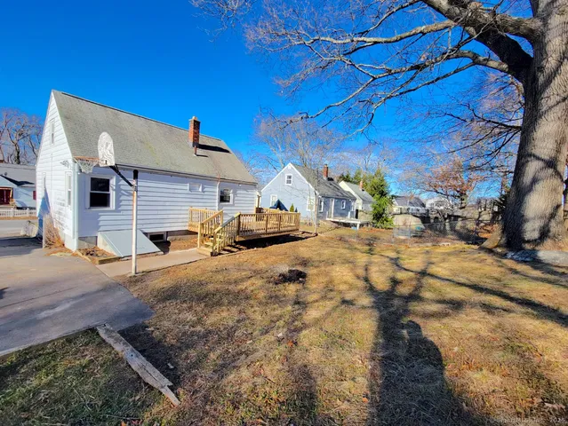 a view of a white house with wooden fence