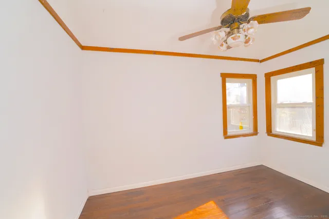 a view of a room with wooden floor and a chandelier fan