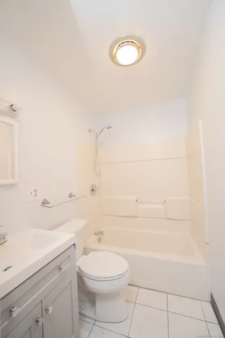 a bathroom with a toilet a sink a mirror and bathtub