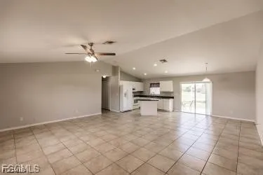 a view of an empty room and chandelier fan