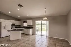 a kitchen with stainless steel appliances granite countertop a stove top oven a sink a counter top space cabinets and a window