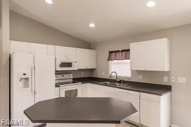 a kitchen with stainless steel appliances granite countertop a sink a stove a refrigerator a counter top space and cabinets