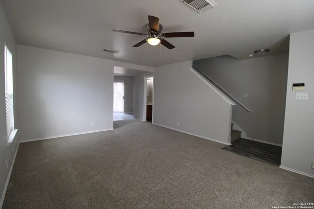 a view of an empty room with a ceiling fan