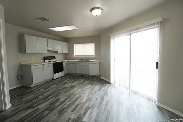 a kitchen with a sink wooden floor and window