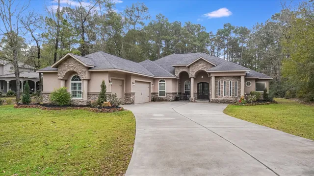 a front view of a house with yard and green space