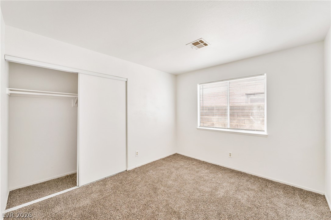 4904 Spring Falls Way North Las Vegas, NV 89031 - Photo 18 of 24 A well-proportioned bedroom offers ample space, a window with blinds, and convenient closet access.
