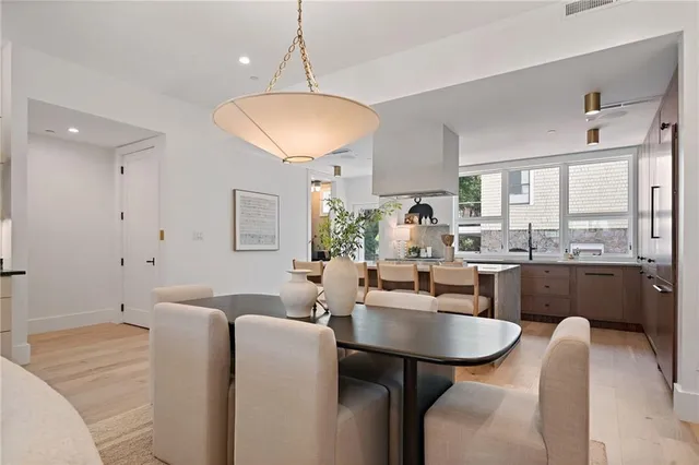 a kitchen with a dining table chairs cabinets and stainless steel appliances