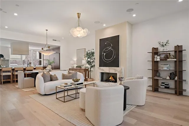 a living room with furniture a fireplace and a chandelier