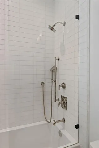a bathroom with a granite countertop sink a toilet and shower