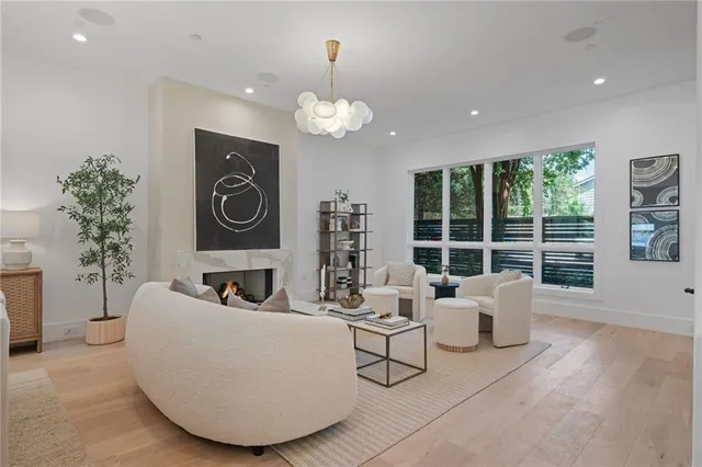 a living room with fireplace furniture and a large window