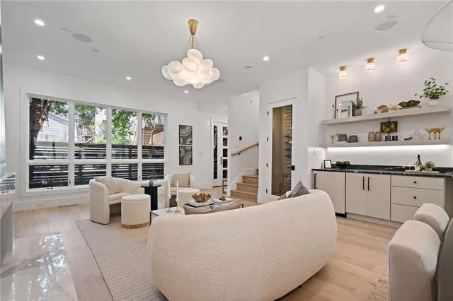 a living room with furniture kitchen view and large windows