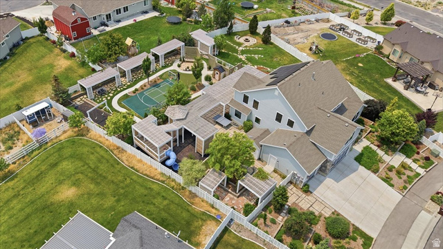 2038 East Ranch Road Eagle Mountain, UT 84005 - Photo 61 of 66 Expansive property featuring a multi-story residence with a gray exterior, a large paved driveway, a dedicated basketball court, multiple covered patio areas, and a substantial fenced yard