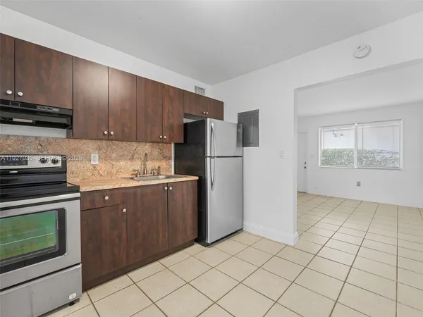 a kitchen with a stove a refrigerator and cabinets
