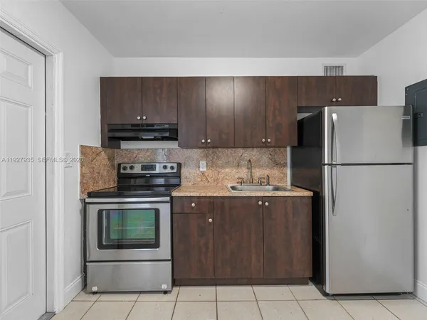 a kitchen with stainless steel appliances granite countertop a refrigerator stove a sink and a microwave