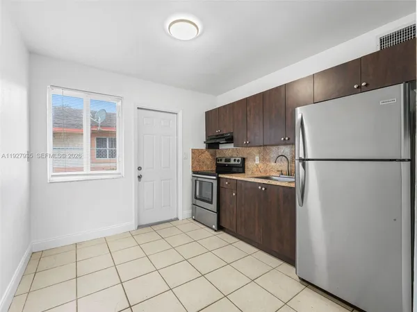 a kitchen with a refrigerator sink stove and cabinets