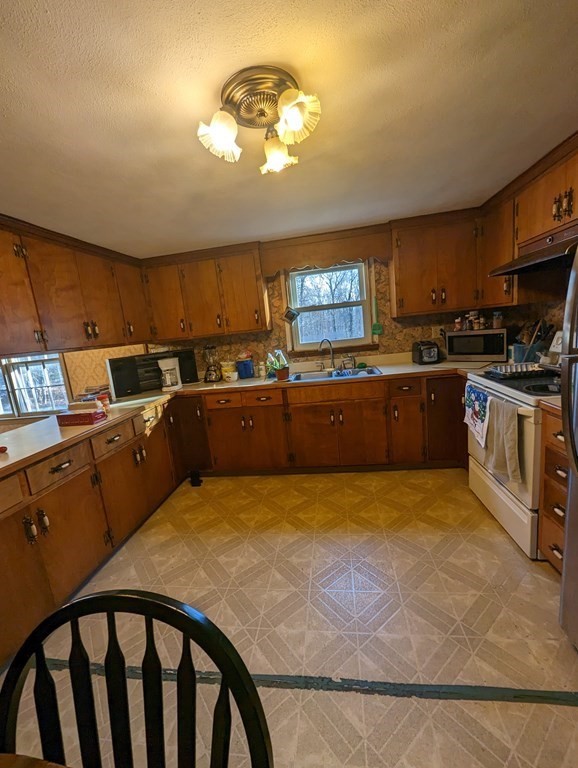 34 Colonial Road Sutton, MA 01590 - Photo 3 of 34 a kitchen with kitchen island a stove a sink a counter space and a window