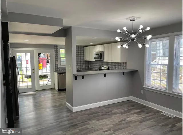 a large white kitchen with a large window
