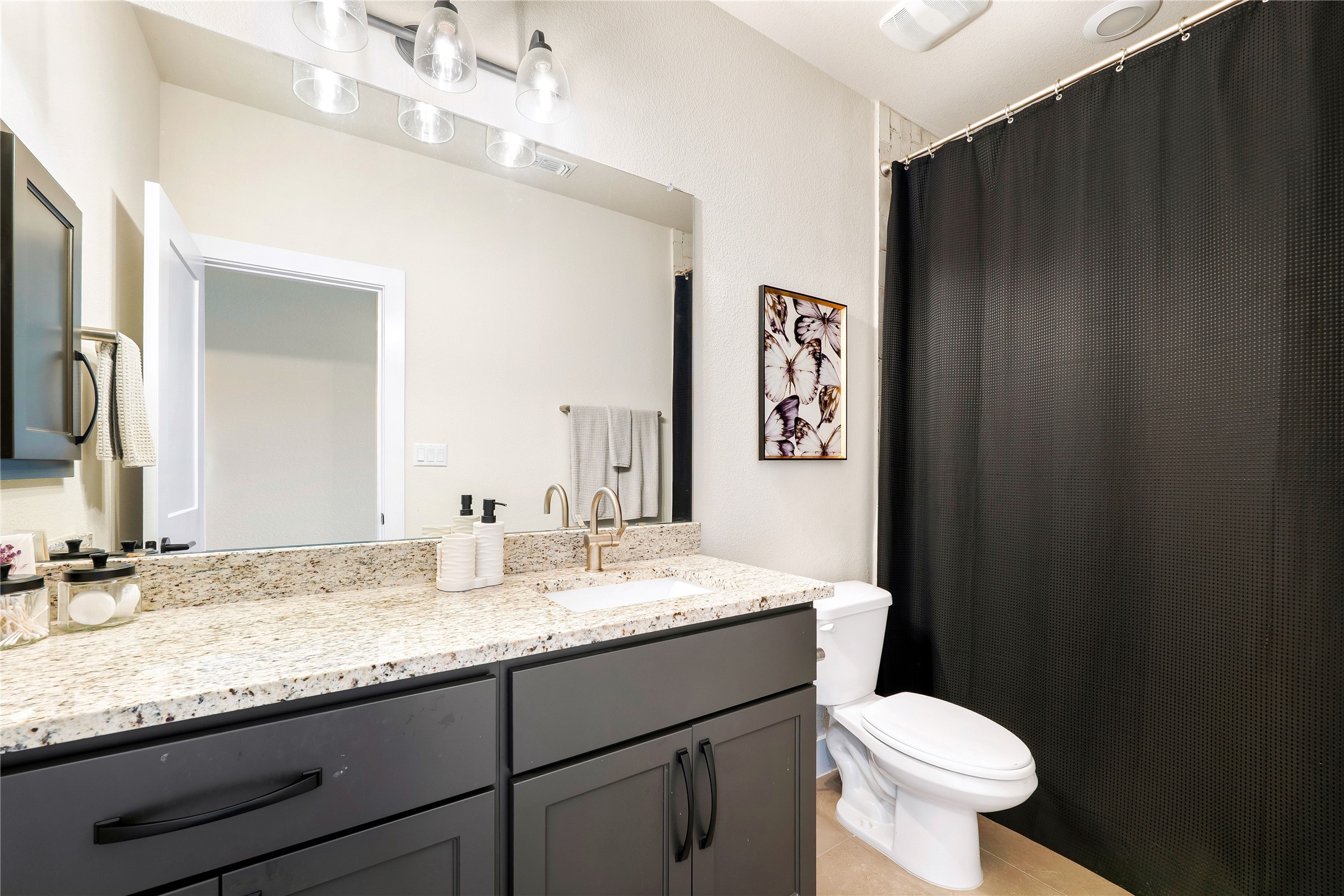 2408 Nate's Place Georgetown, TX 78633 - Photo 30 of 40 A well-appointed bathroom features a spacious granite vanity and sleek dark cabinetry.