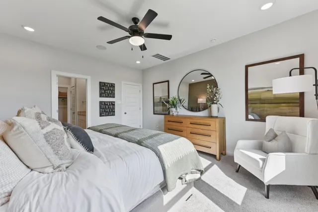 a bedroom with a large bed and ceiling fan