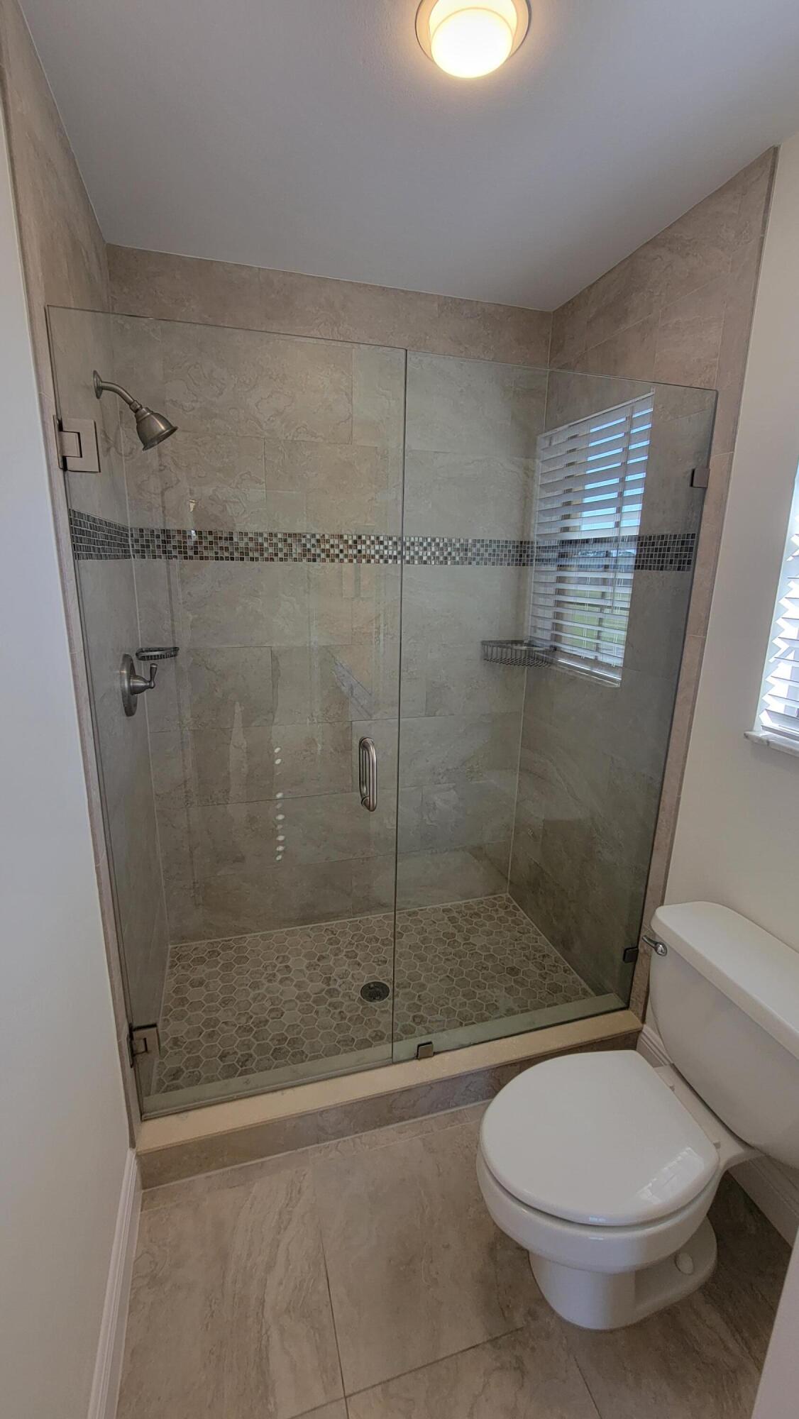 1072 Keystone Drive, Unit A Jupiter, FL 33458 - Photo 18 of 29 a bathroom with a toilet and a shower