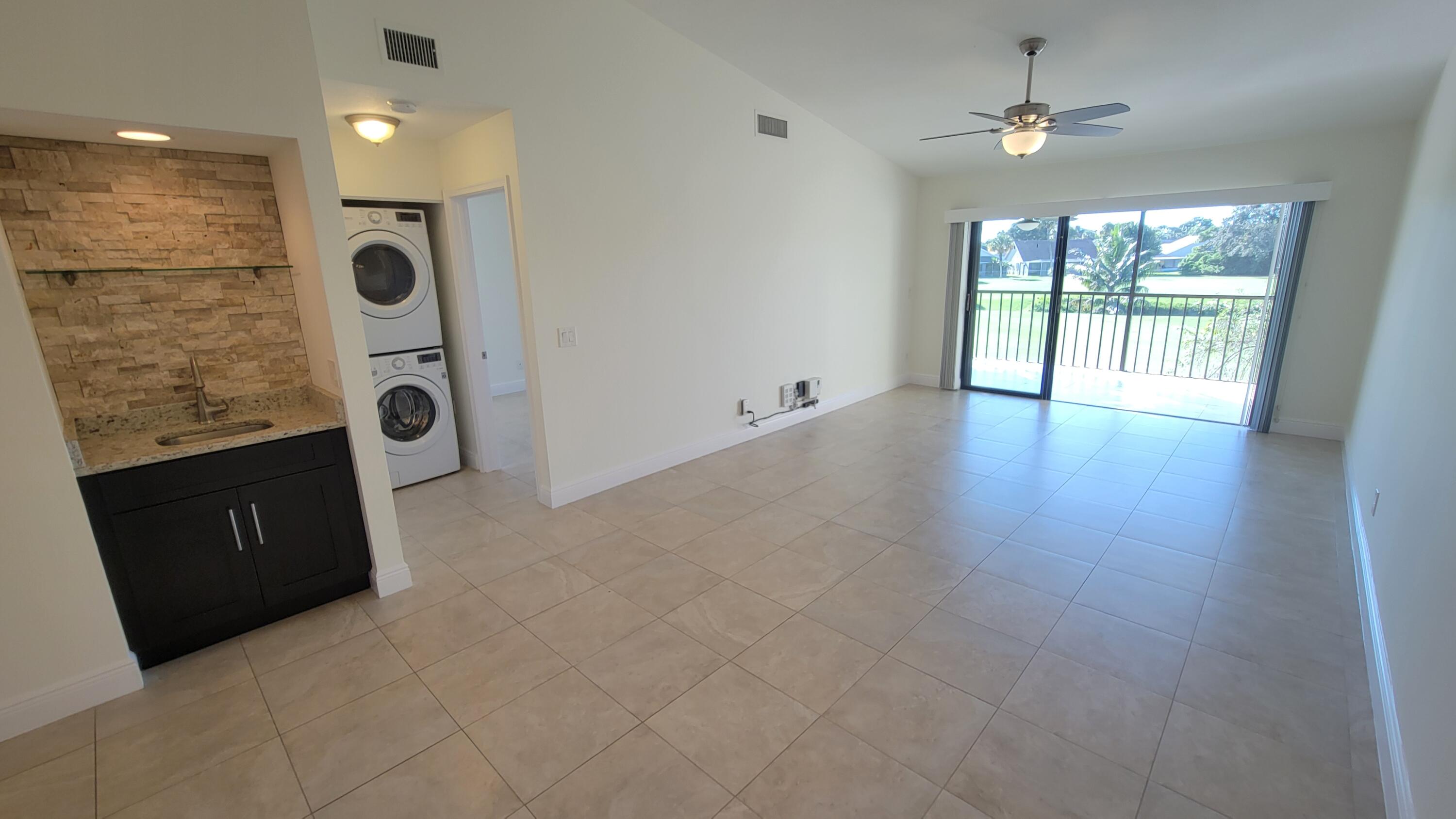 1072 Keystone Drive, Unit A Jupiter, FL 33458 - Photo 5 of 29 wooden floor in an empty room with a window