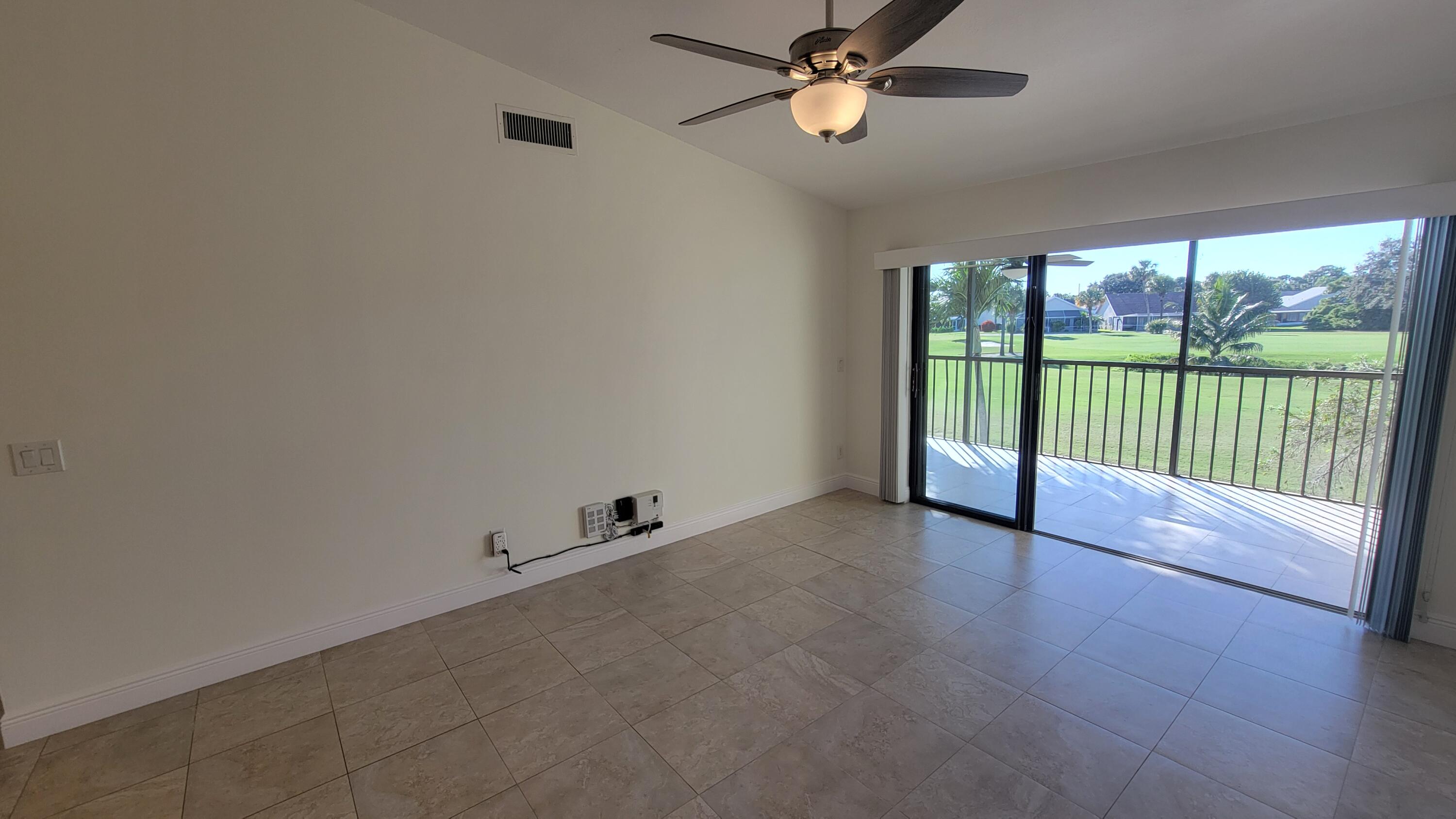 1072 Keystone Drive, Unit A Jupiter, FL 33458 - Photo 7 of 29 wooden floor in an empty room with a window
