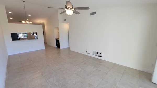 an empty room with a ceiling fan and a window
