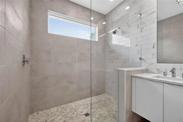 a bathroom with a shower sink and mirror