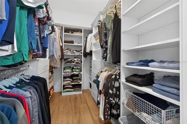 a view of walk in closet with clothes and shoes