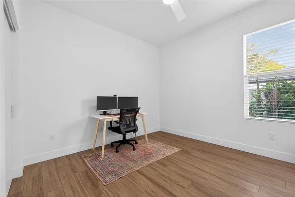 a view of a workspace with wooden floor and a window