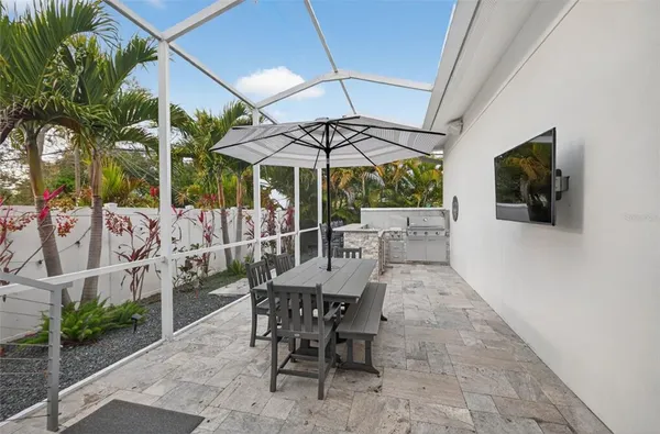 a view of a patio with a table and chairs under an umbrella