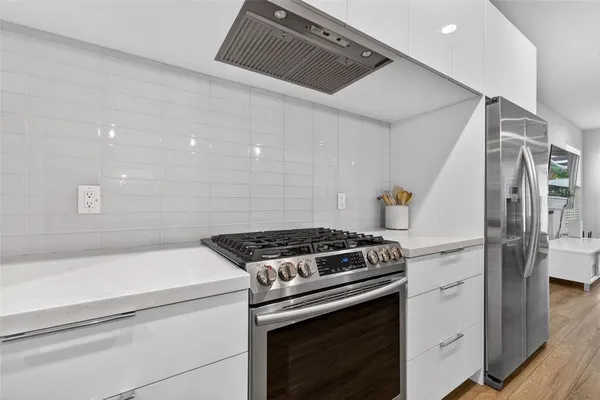 a kitchen with a stove and white cabinets
