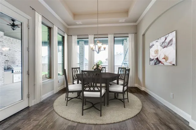 a dining room with furniture a chandelier and wooden floor