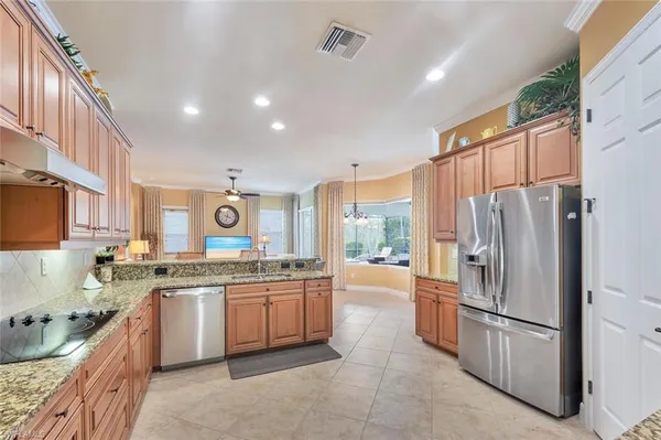 a kitchen with stainless steel appliances granite countertop a refrigerator sink and cabinets